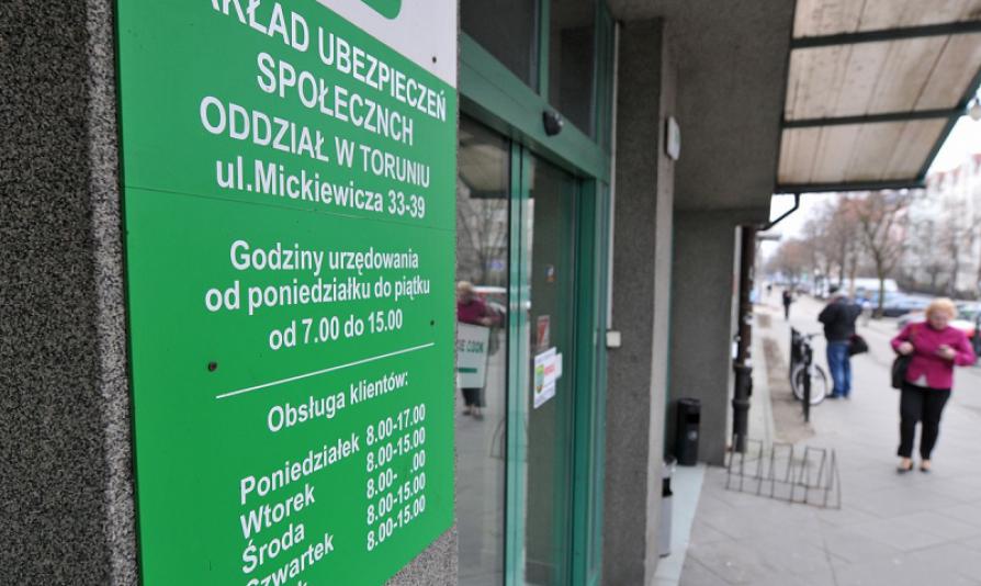 Na zdjęciu tablica informacyjna z napisem Zakład Ubezpieczeń Społecznych Oddział w Toruniu