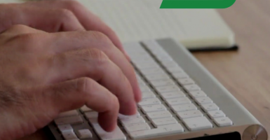 Zdjęcie przedstawia dłonie na klawiaturze i logotyp ZUS