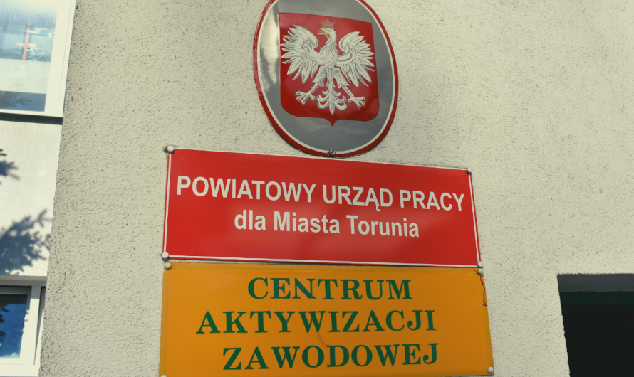 Polskie godło i szyldy wiszące przed wejściem do Powiatowego Urzędu Pracy dla Miasta Torunia przy ulicy Mazowieckiej w Toruniu